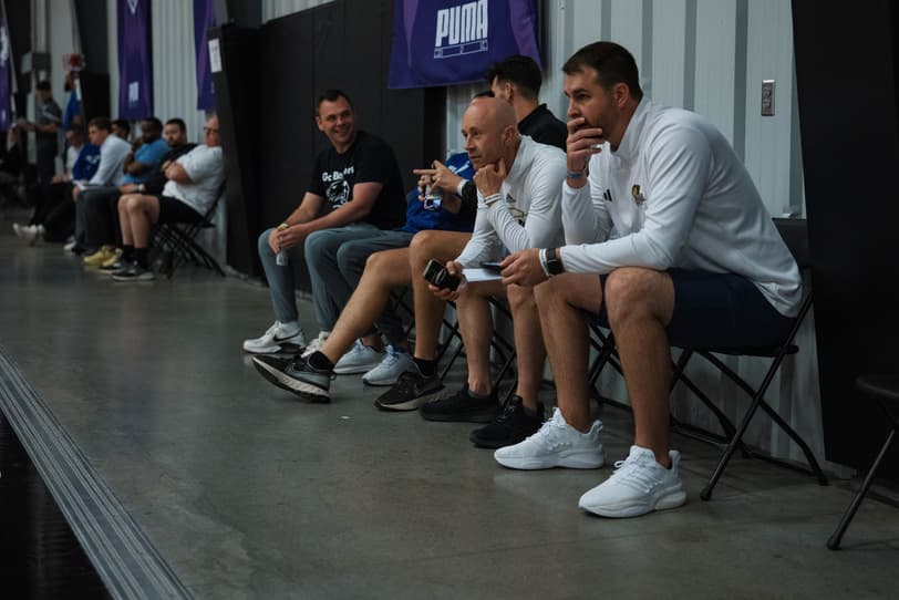 College coaches watching from the sideline at an AAU tournament