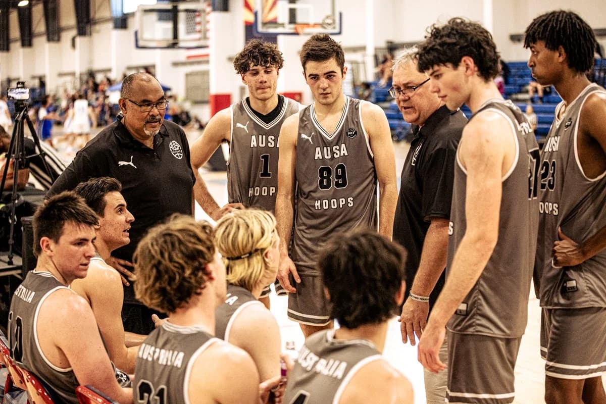 An AUSA Hoops coach addressing the team in a huddle during a US AAU tournament