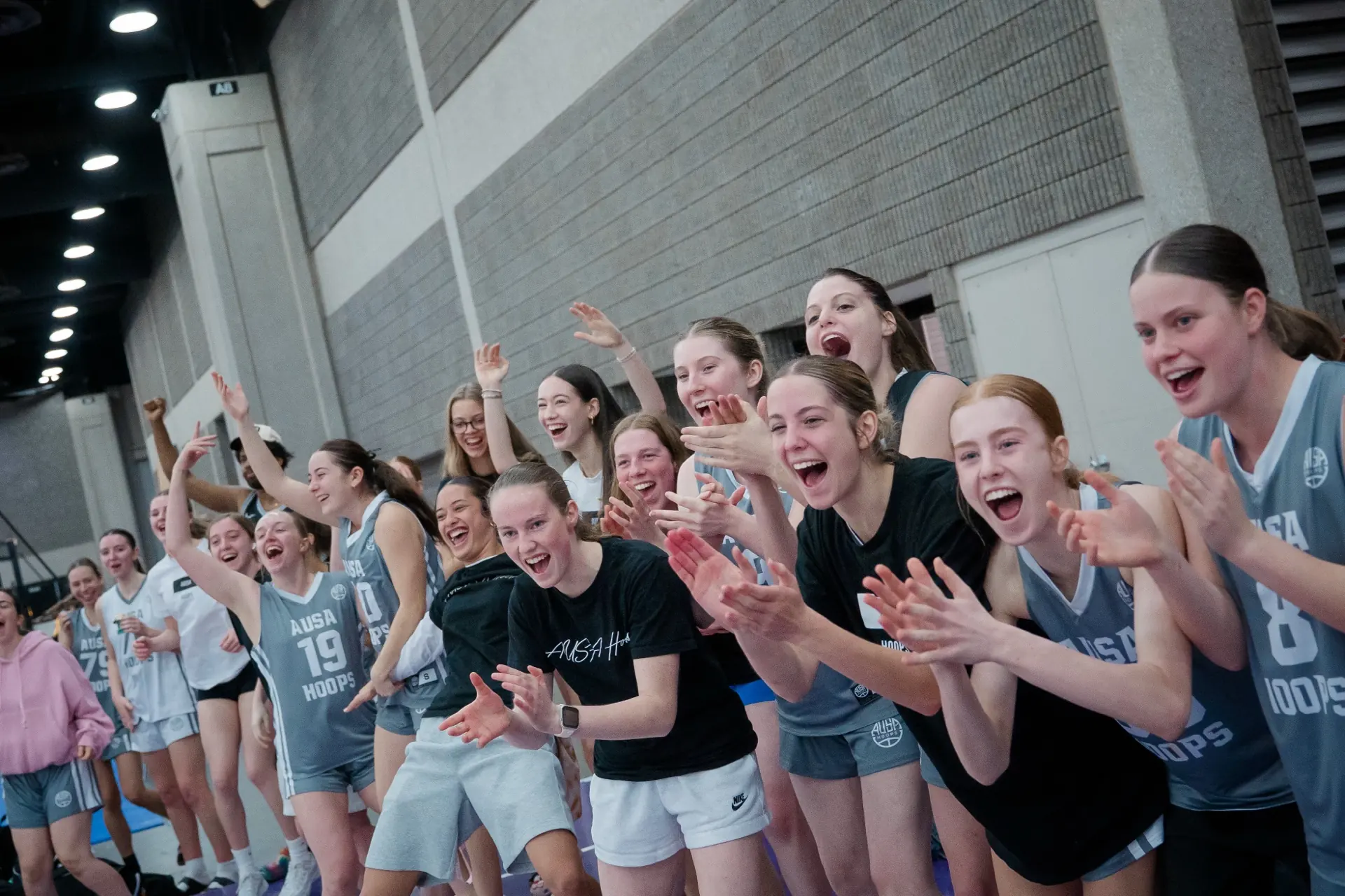 AUSA Hoops squad cheering their teammates from the sideline