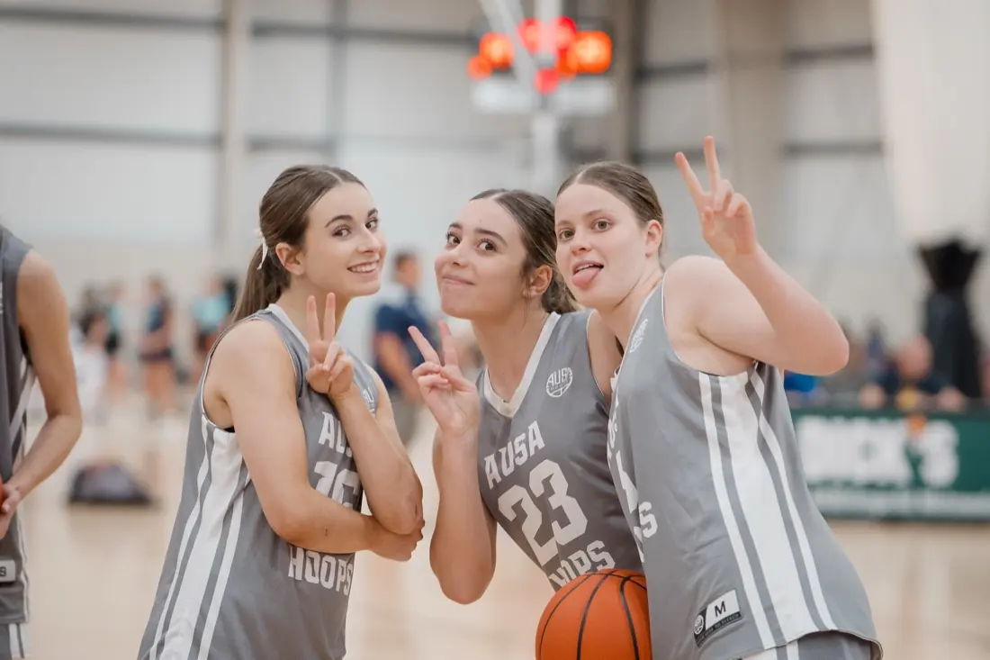 Three AUSA Hoops teammates pulling faces for the camera at a tournament