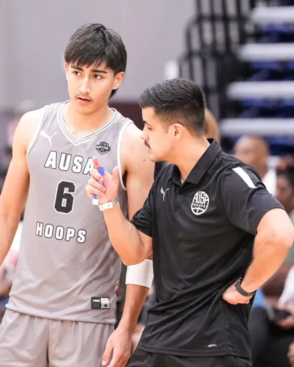 AUSA Hoops coach Fernando Rios-Rodriguez talking a player through a decision courtside at a US tournament
