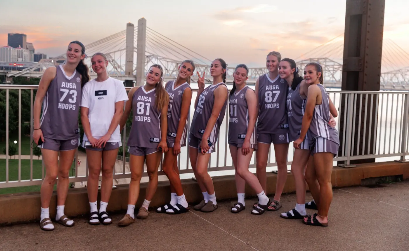 AUSA Hoops girls squad together on a bridge at sunset