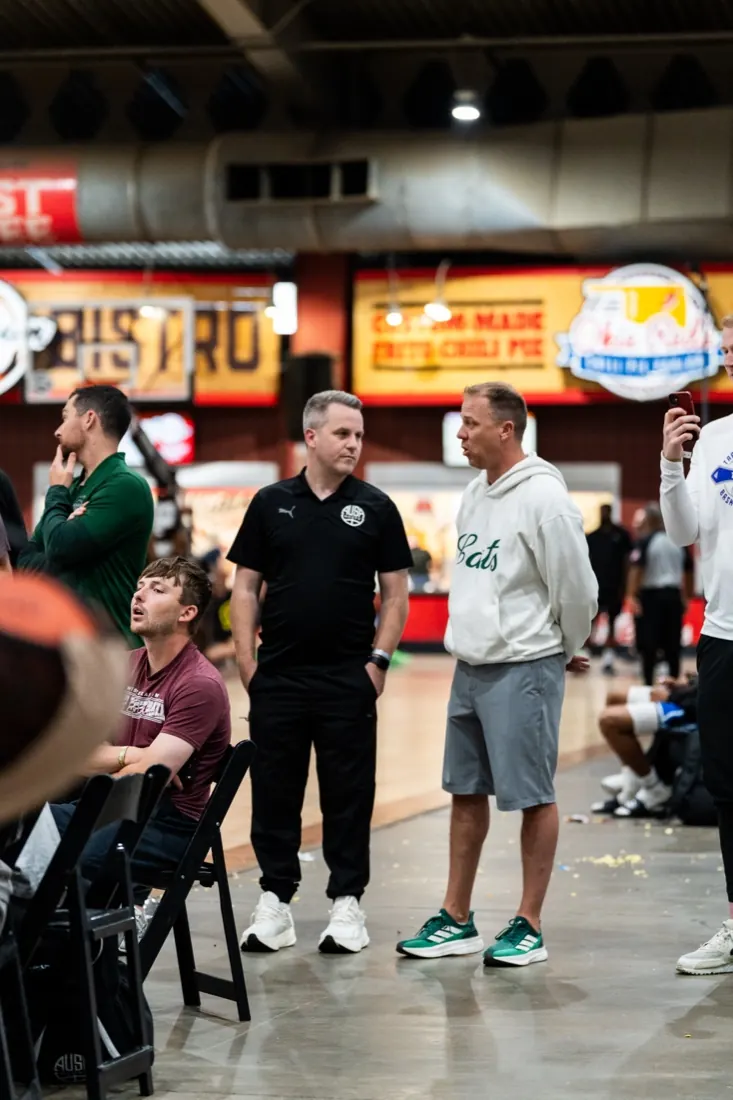 AUSA Hoops staff member talking with a college coach on the floor at a US tournament