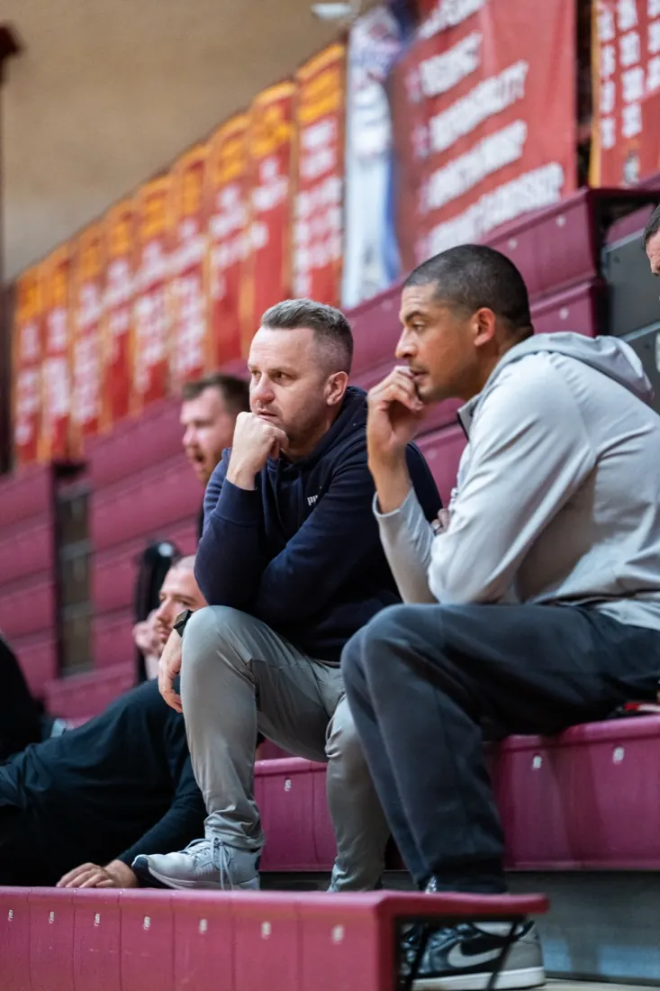 Coaches watching a game intently from the stands